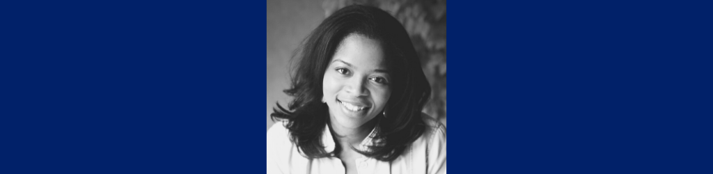 A woman smiles in a black and white photo