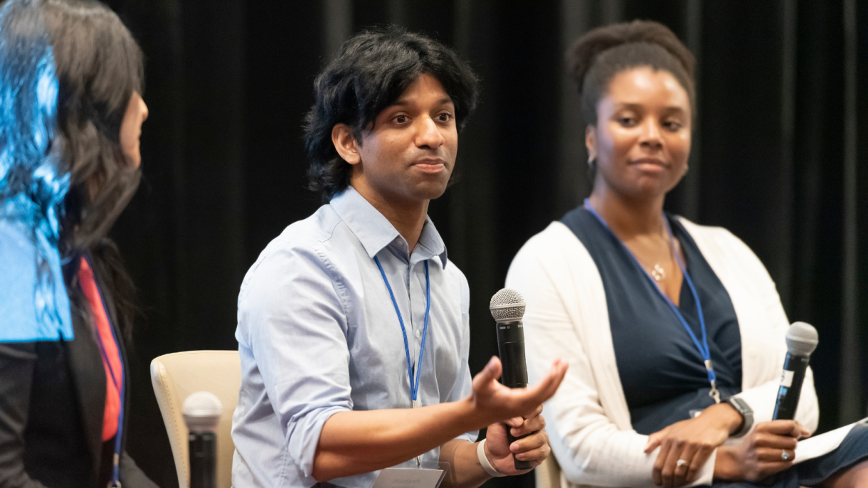 Faculty panelist gestures as another looks on.