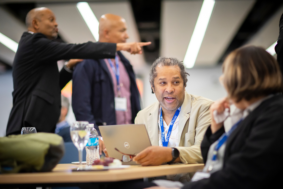 Jay Pearson talks with a colleague while seated at a table during a workshop session.