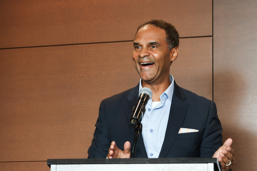 Alec Gallimore smiles during his talk at the podium.